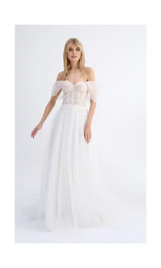  `Kobieta w eleganckiej, białej sukni ślubnej z odkrytymi ramionami.` 