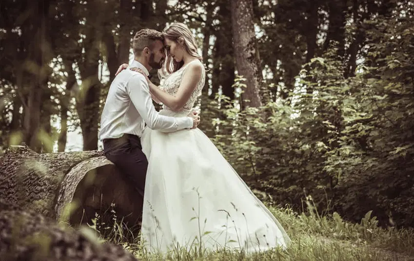  Para młoda w romantycznej sesji ślubnej na łonie natury, panna młoda w białej sukni, pan młody w eleganckiej koszuli, romantyczne ujęcie w lesie 