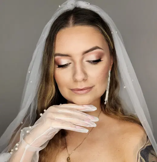  Nieznana kobieta w ślubnej sukience z welonem, delikatny makijaż, eleganckie rękawiczki, neutralne tło. 
