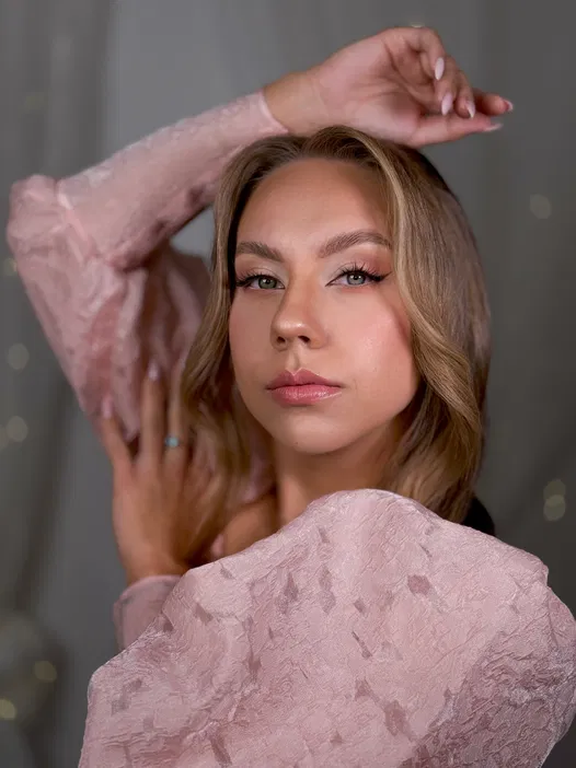 Nie znam osoby na zdjęciu. Kobieta w różowej sukni o gładkich włosach pozuje w eleganckiej scenerii.