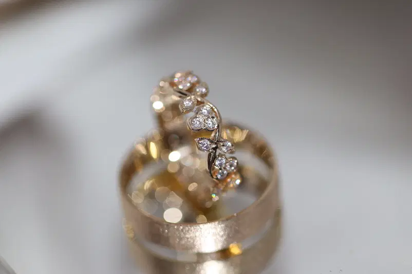  Złote obrączki ślubne z diamentami na białym tle, elegancka biżuteria na specjalne okazje. 