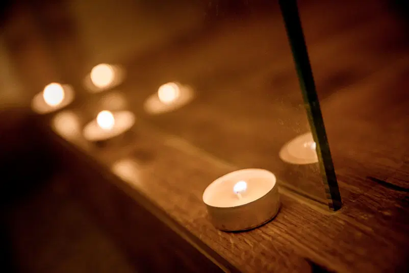  Świeczki tealight na drewnianej powierzchni, tworzące przytulny nastrój. 