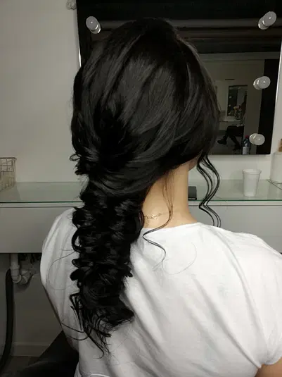  Ciemne, kręcone włosy upięte w elegancką fryzurę z delikatnymi lokami, widok z tyłu, salon fryzjerski. 