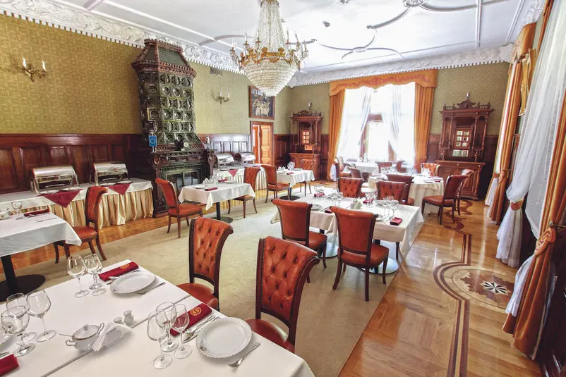  Elegancka restauracja z klasycznym wystrojem wnętrza, stylowe meble i ozdobny żyrandol, przygotowana na elegancką kolację. 