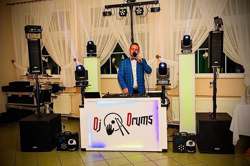  DJ na weselu z profesjonalnym sprzętem muzycznym, dekoracja świateł, elegancka sala, muzyczna oprawa imprez, DJ Drums. 
