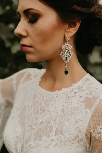  Zbliżenie na kobietę w koronkowej sukni z eleganckimi kolczykami. 