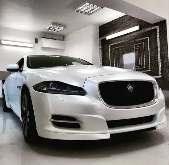  Luksusowy biały samochód sportowy w eleganckim garażu, widok z przodu. 