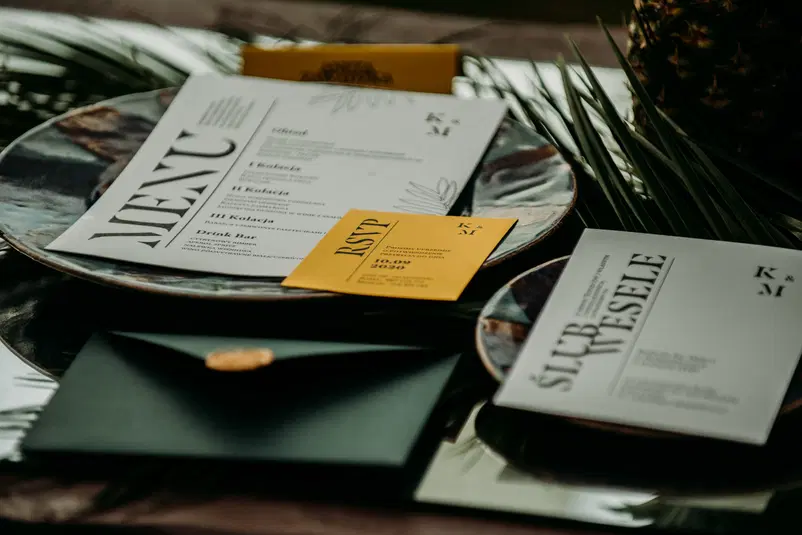  Ślubne zaproszenia i menu na stole z liśćmi, elegancki wystrój, wesele, przyjęcie, RSVP. 