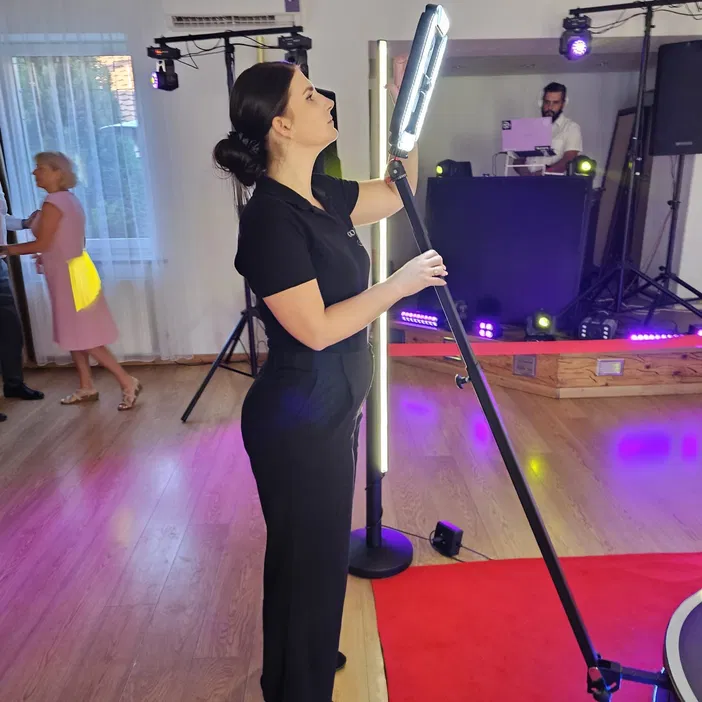 Personel ustawia sprzęt oświetleniowy na imprezie z DJ-em i parkietem tanecznym.