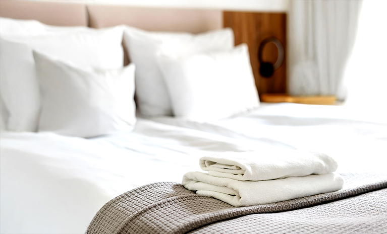  Luksusowy pokój hotelowy z elegancko ułożonymi białymi ręcznikami na łóżku. 
