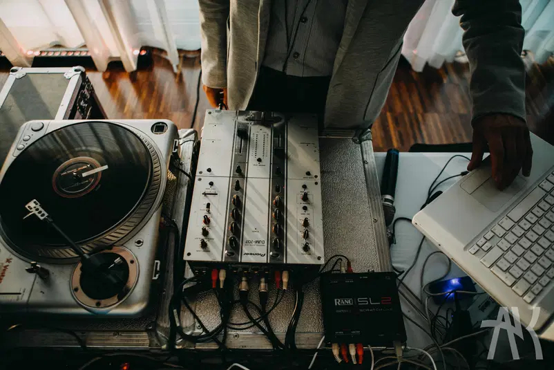  DJ przy konsoli mikserskiej, gramofon z winylem i laptopem, wyposażenie muzyczne profesjonalnego DJ-a w akcji. 