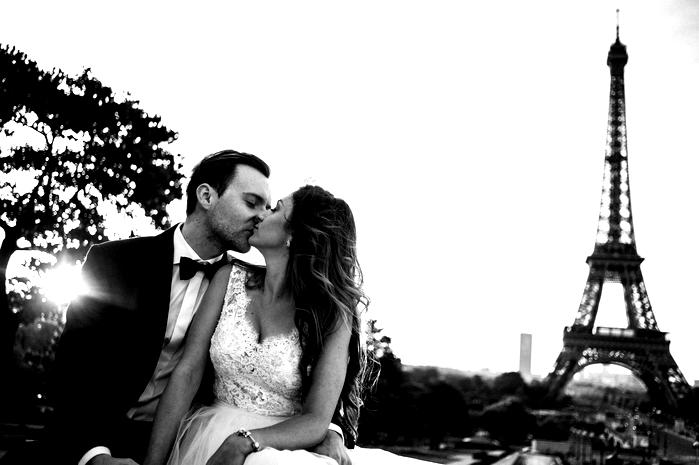  Para młoda całująca się przed Wieżą Eiffla w Paryżu, romantyczne zdjęcie ślubne, czarno-biała fotografia, miłość i małżeństwo w stolicy Francji. 