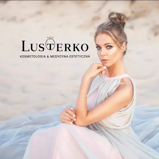  Kobieta w jasnej sukience siedząca na piasku, logo Lusterko Kosmetologia & Medycyna Estetyczna obok twarzy, eleganckie upięcie włosów, estetyczna fotografia w plenerze. 