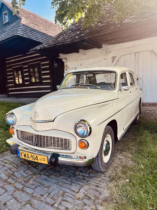 Zabytkowy samochód retro na brukowanej uliczce przed drewnianym domem, klasyczna motoryzacja, nostalgia, historia motoryzacji.