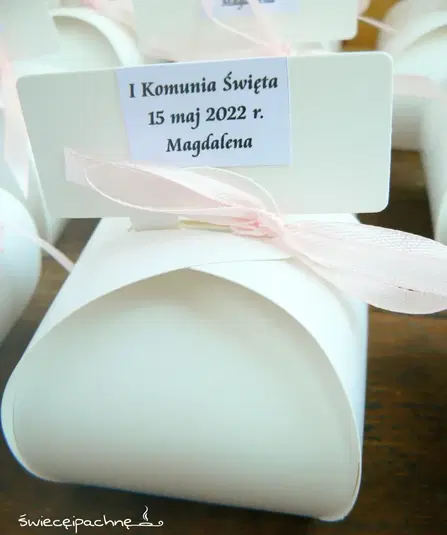  Pudełeczko z kartonikiem na I Komunię Świętą, ozdobione różową wstążką, z datą 15 maj 2022 r. i imieniem Magdalena. 