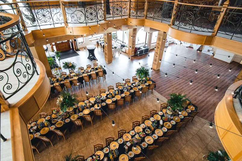  Duża sala bankietowa z ustawionymi eleganckimi stołami i krzesłami, gotowa na przyjęcie weselne lub event, elegancki wystrój wnętrza, widok z góry. 