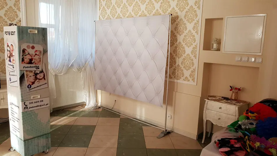  Fotobudka na wesele z białym tłem, elegancka aranżacja wnętrza, dekoracyjne tło, rekwizyty do zdjęć. 