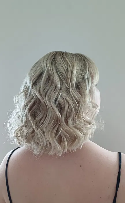 Blond włosy z delikatnymi falami, krótkie cięcie, tył głowy, naturalny wygląd, fryzura na co dzień.