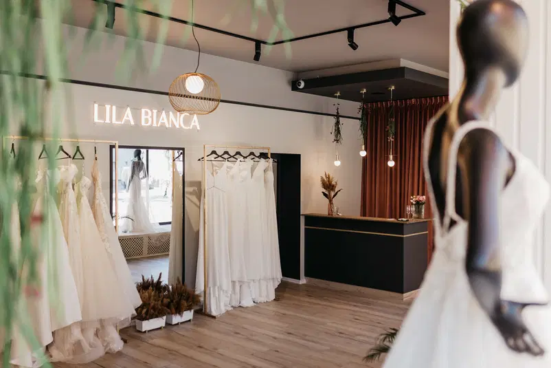 Salon sukien ślubnych Lila Bianca z eleganckim wystrojem wnętrza i manekinami w białych sukniach ślubnych, stylowe oświetlenie i dekoracje. 