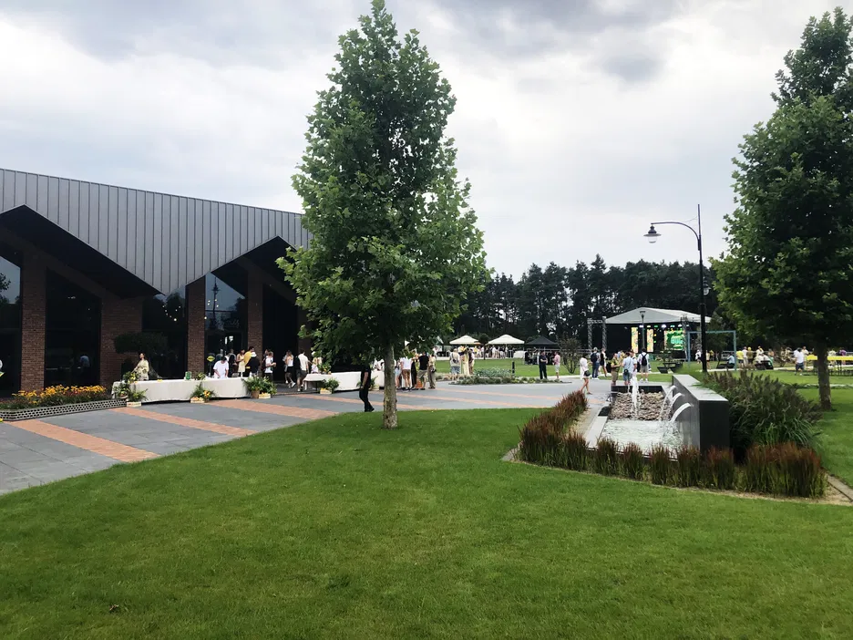Nowoczesne centrum konferencyjne z ogrodem i fontanną na świeżym powietrzu podczas wydarzenia plenerowego.