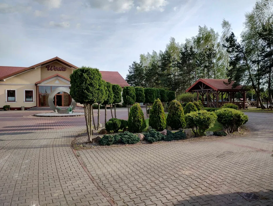 Dom weselny z pięknie zagospodarowanym terenem, ozdobionym zielenią, alejkami i altaną, idealne miejsce na przyjęcie weselne.